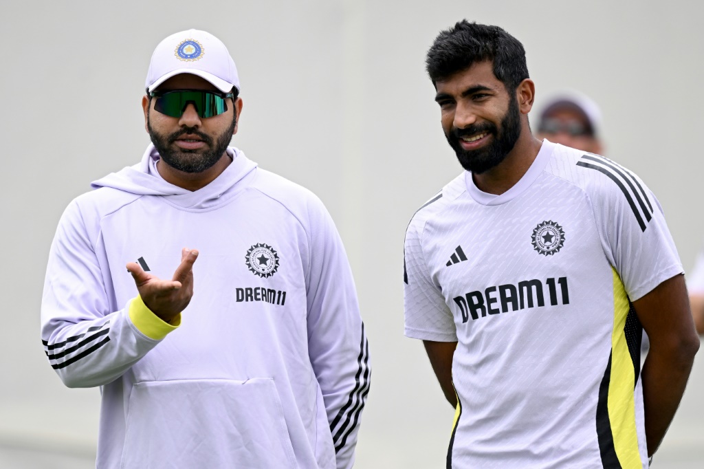 Rohit Sharma (L) chats with teammate Jasprit Bumrah, AFP