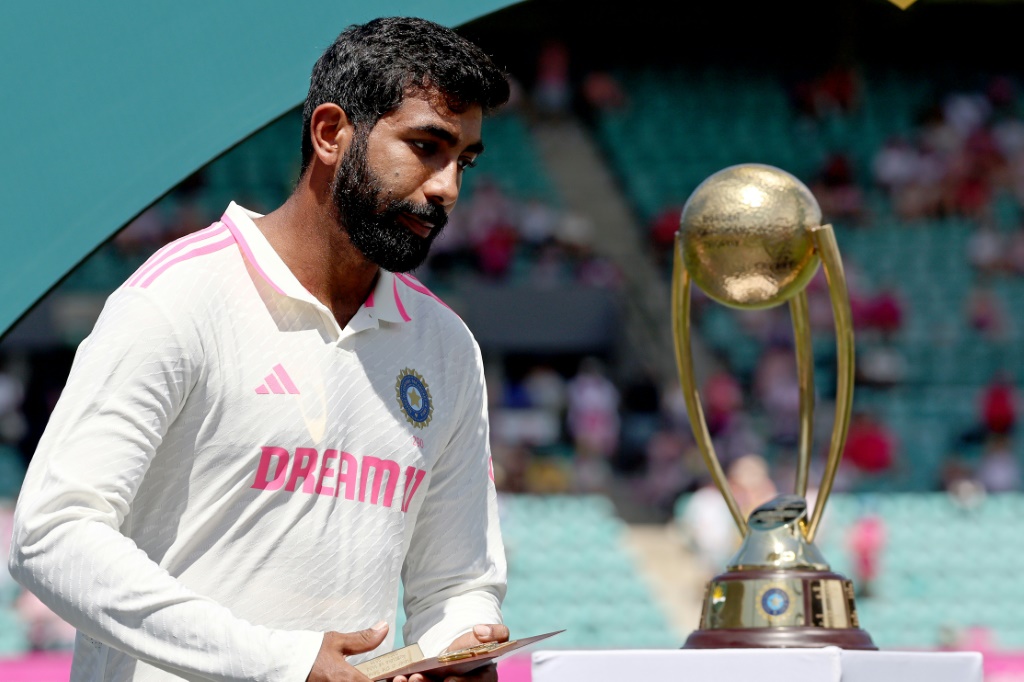 India’s Jasprit Bumrah walkls past the Border-Gavaskar trophy, AFP