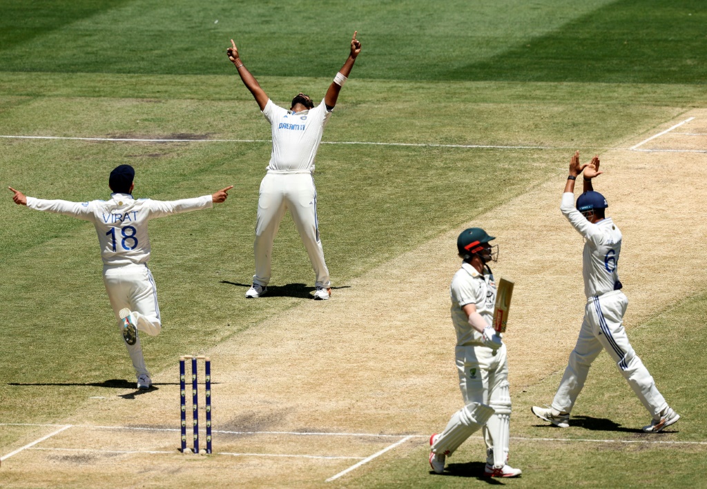 Jasprit Bumrah (second left) and Virat Kohli (left) celebrate the wicket of Travis Head, AFP