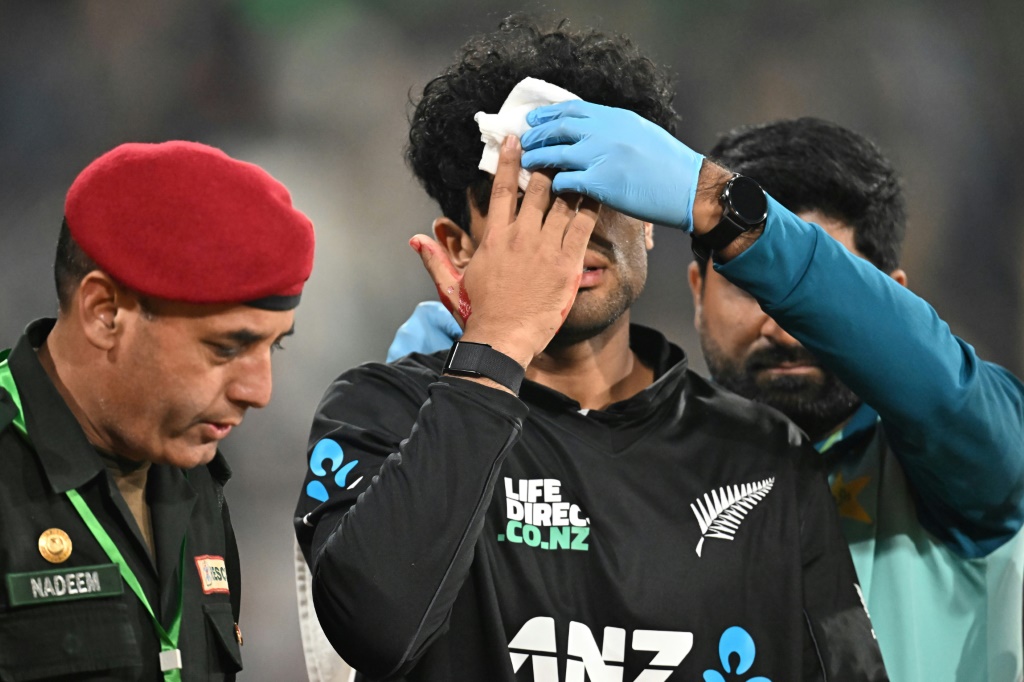 New Zealand's Rachin Ravindra leaves the field after being hit on the head by the ball, AFP