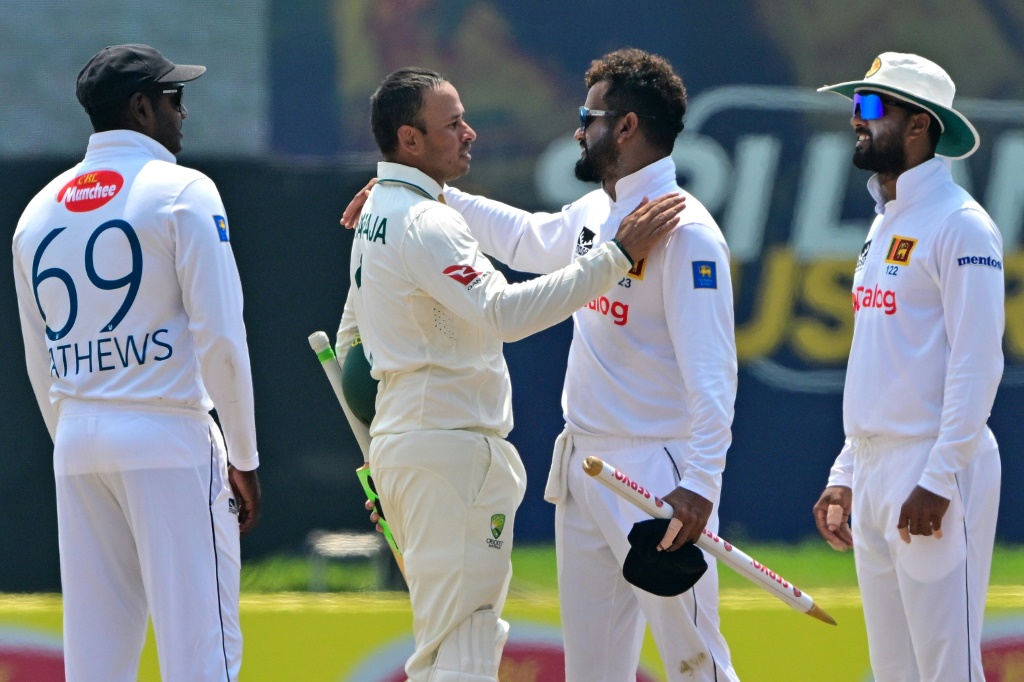 Australia's Usman Khawaja (second left) congratulates the retiring Dimuth Karunaratne (second right) of Sri Lanka at the end of the second Test, AFP