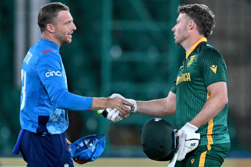 Jos Buttler (L) shakes hands with South Africa's David Miller after England suffered a heavy defeat in his final match as captain, AFP