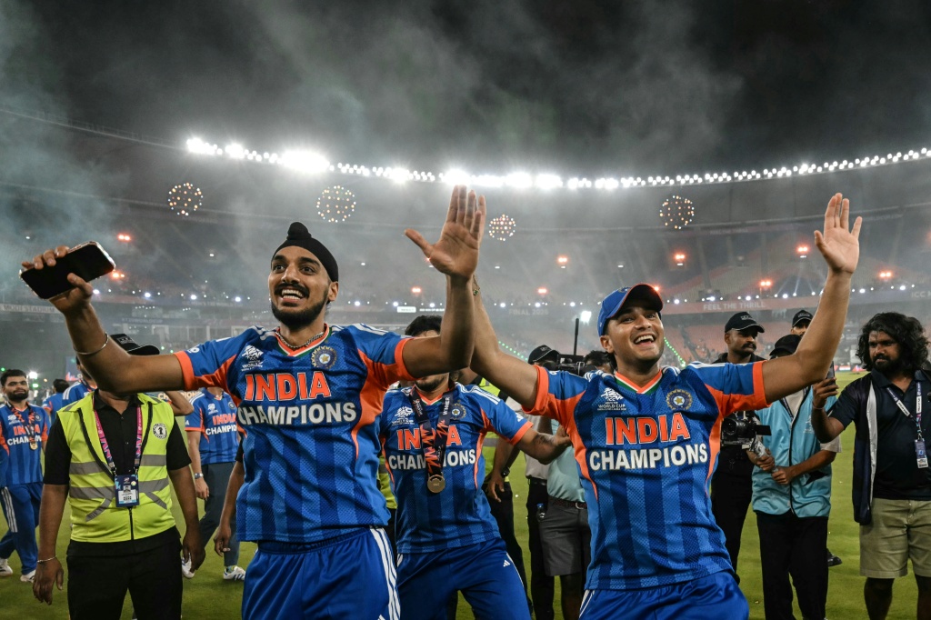 India's Arshdeep Singh (L) and Abhishek Sharma dance during a victory lap