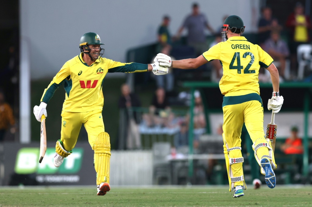 Australia’s Cameron Green (R) reacts with teammate Alex Carey after reaching his century during the third ODI against South Africa